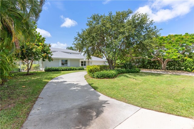 25 Park Ave, Vero Beach, FL 32960 - view of front of house with driveway, metal roof, and stucco siding