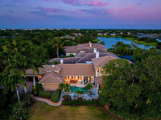 aerial view at dusk featuring a water view