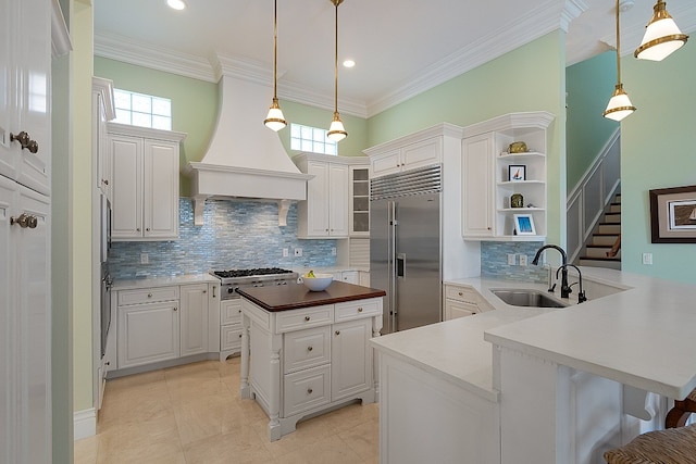 kitchen featuring white cabinetry, sink, stainless steel appliances, backsplash, and kitchen peninsula