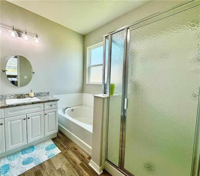 bathroom with separate shower and tub, vanity, and hardwood / wood-style flooring