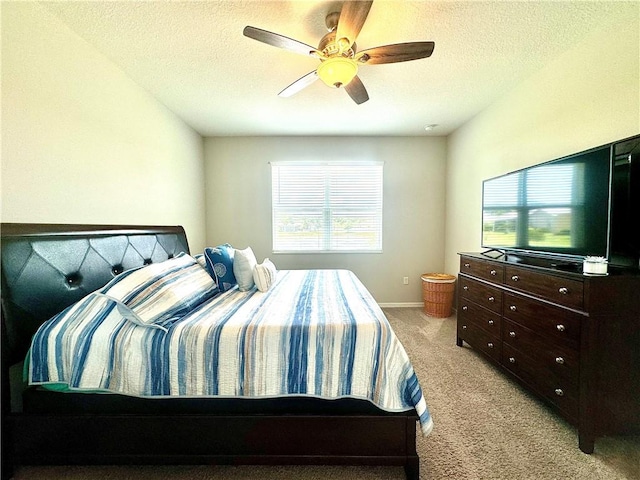 carpeted bedroom with ceiling fan and a textured ceiling