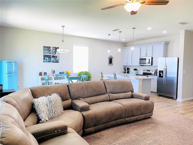 living room featuring ceiling fan and light hardwood / wood-style floors