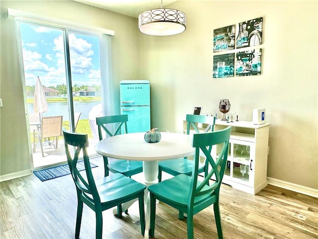 dining room featuring hardwood / wood-style floors and a water view