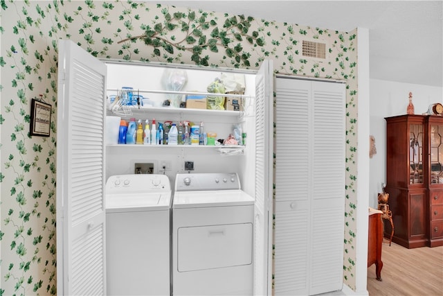 laundry area with light wood-type flooring and washing machine and dryer