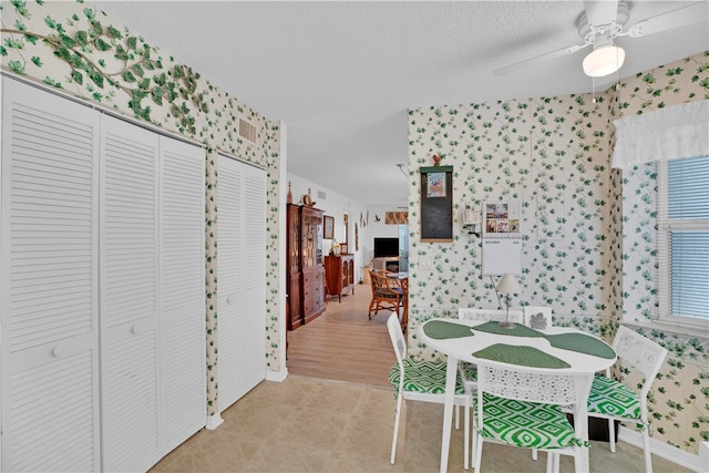 dining room with light hardwood / wood-style flooring, ceiling fan, and a textured ceiling