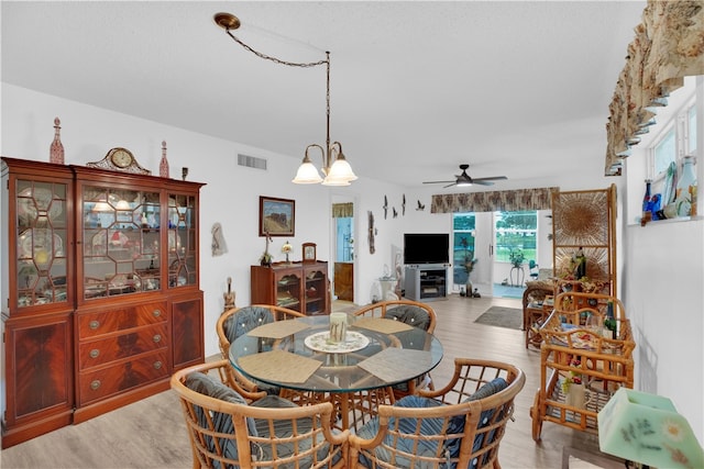 dining space featuring hardwood / wood-style floors and ceiling fan with notable chandelier