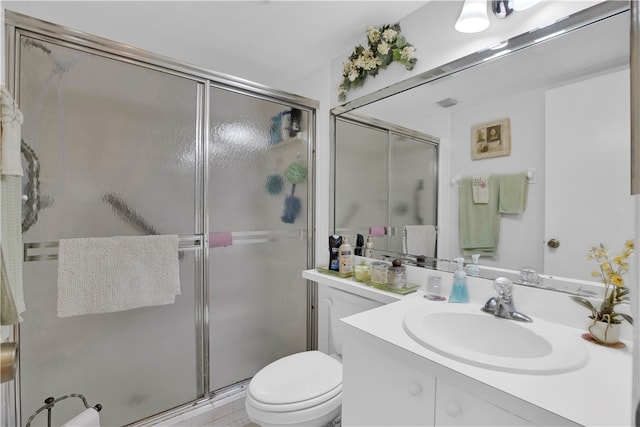 bathroom featuring tile patterned flooring, vanity, toilet, and an enclosed shower