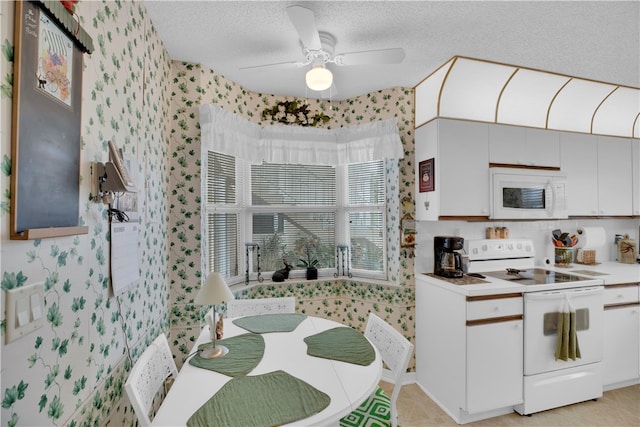 kitchen with white appliances, white cabinets, ceiling fan, and a textured ceiling