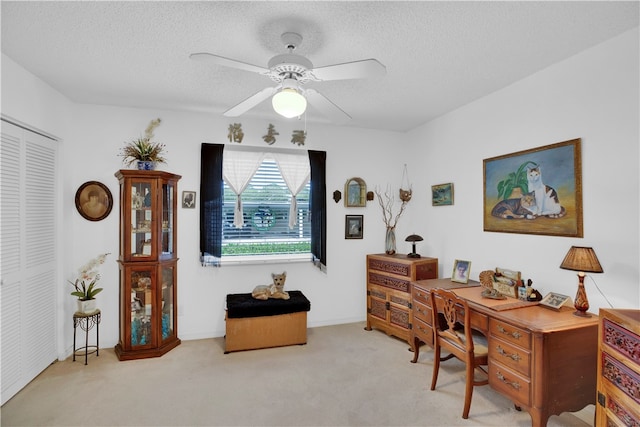 office area featuring ceiling fan, light carpet, and a textured ceiling