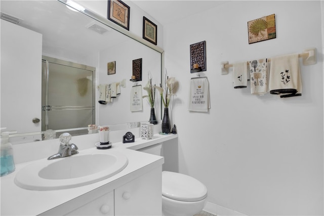 bathroom with vanity, toilet, and a shower with shower door