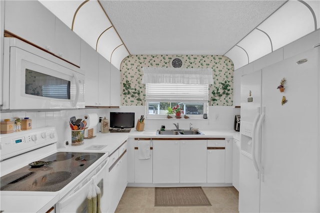 kitchen featuring a textured ceiling, sink, white cabinets, and white appliances