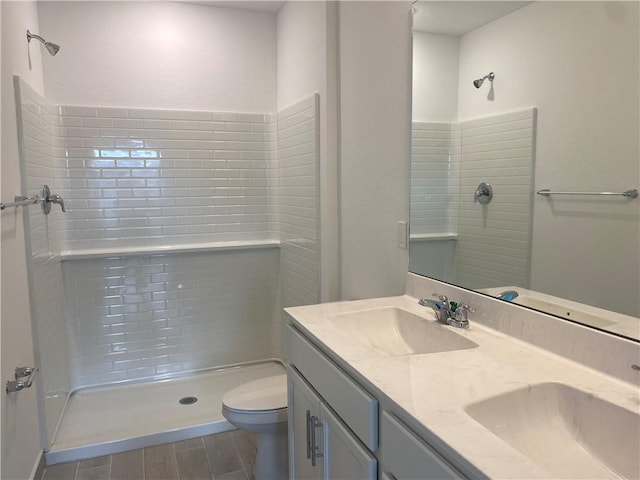 bathroom with a shower, wood-type flooring, vanity, and toilet