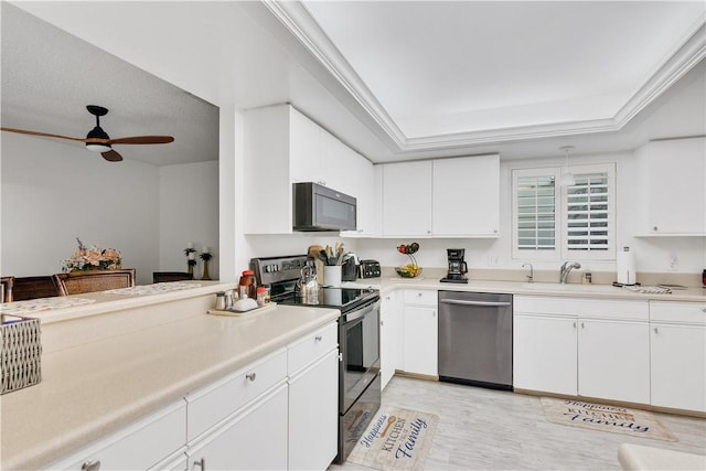 kitchen featuring sink, white cabinets, black range with electric cooktop, stainless steel dishwasher, and a raised ceiling