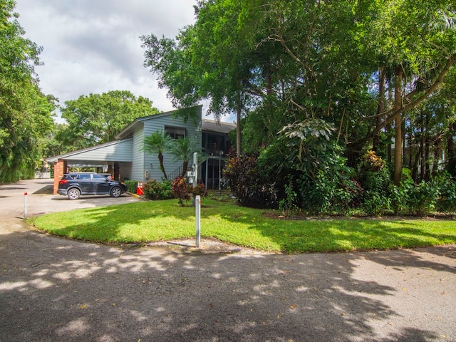 view of front of property with a carport and a front lawn