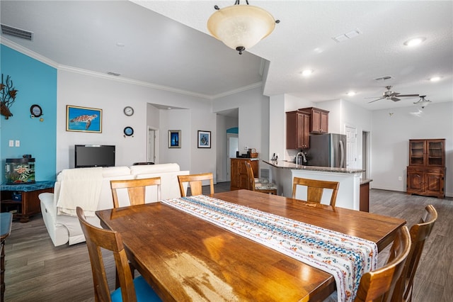 dining area featuring dark hardwood / wood-style floors, ceiling fan, ornamental molding, and a textured ceiling