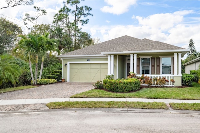 view of front of home featuring covered porch, a front yard, and a garage