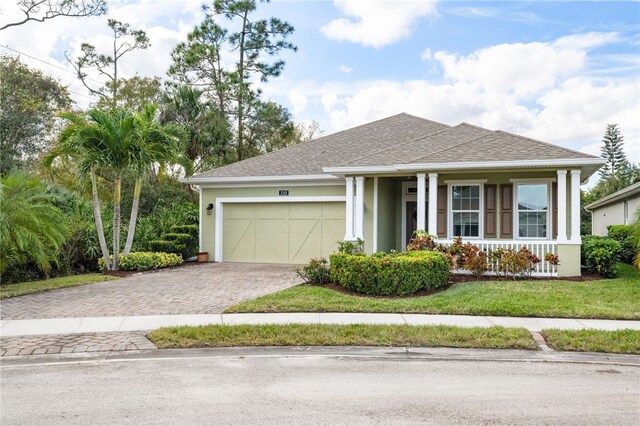 3315 Wild Banyan Way, Vero Beach, FL 32966 - view of front of home featuring covered porch, a front yard, and a garage