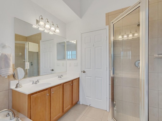 bathroom featuring tile patterned floors, a shower with door, and vanity