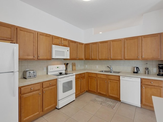 kitchen with sink, tile countertops, light tile patterned floors, white appliances, and decorative backsplash