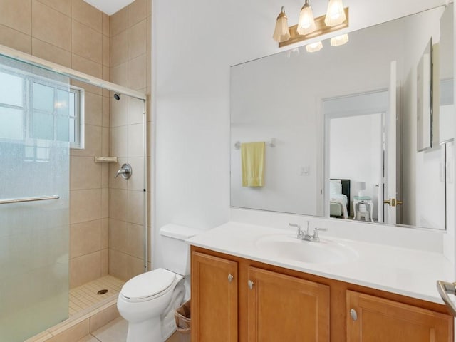 bathroom with a shower with door, vanity, tile patterned flooring, and toilet