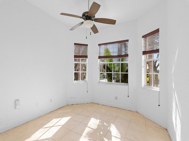 spare room with ceiling fan and light tile patterned flooring