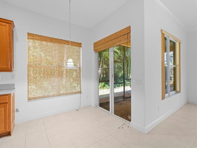 unfurnished dining area featuring light tile patterned floors and crown molding