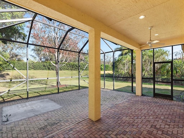 unfurnished sunroom featuring ceiling fan