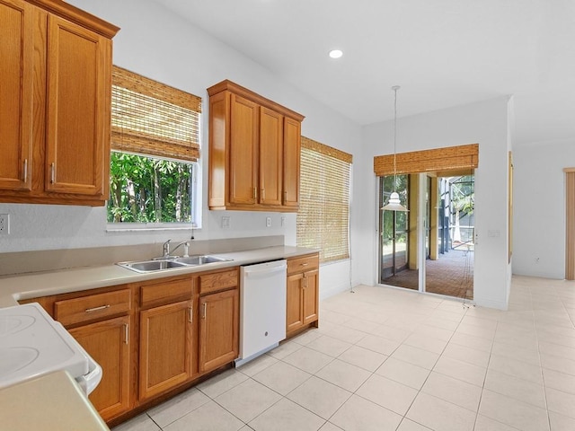 kitchen with pendant lighting, stove, white dishwasher, sink, and light tile patterned flooring