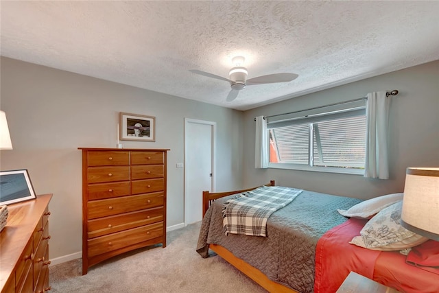 carpeted bedroom with a textured ceiling and ceiling fan