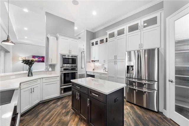 kitchen featuring tasteful backsplash, white cabinets, pendant lighting, and appliances with stainless steel finishes