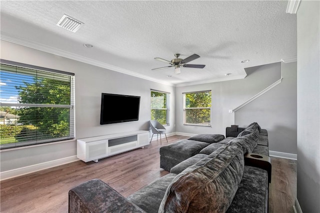 living room with a textured ceiling, ceiling fan, crown molding, and dark wood-type flooring