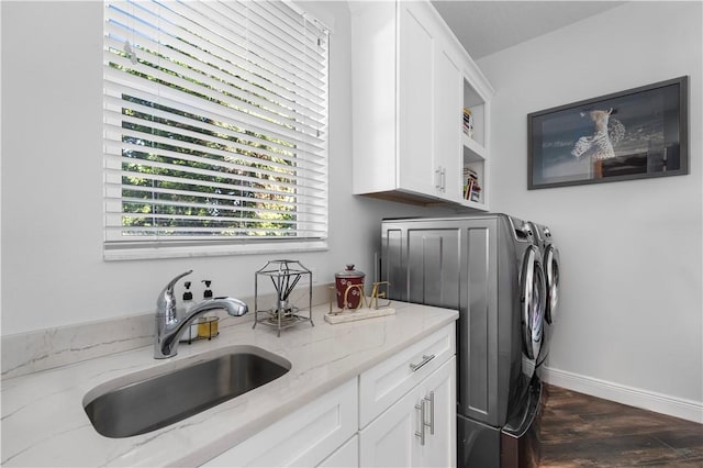 laundry room with washing machine and dryer, sink, cabinets, and dark wood-type flooring