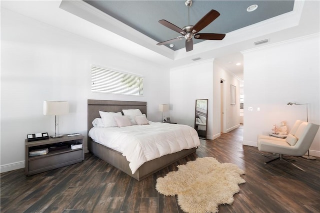 bedroom with dark hardwood / wood-style floors, a raised ceiling, ceiling fan, and ornamental molding