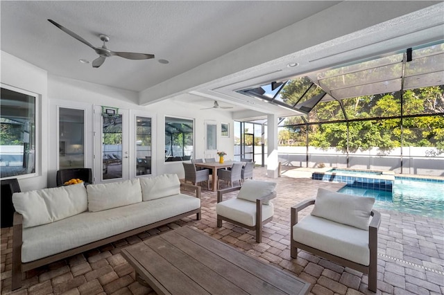 view of patio / terrace with glass enclosure, ceiling fan, a swimming pool with hot tub, and an outdoor hangout area