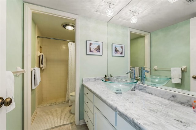 bathroom featuring tile patterned floors, vanity, toilet, and curtained shower