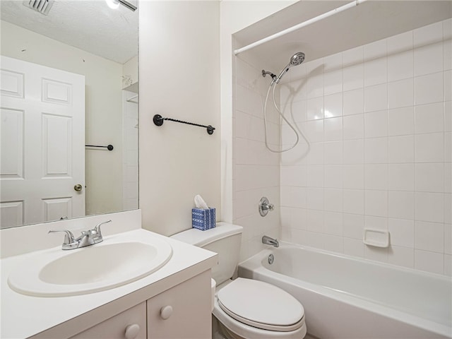 full bathroom featuring tiled shower / bath combo, vanity, a textured ceiling, and toilet