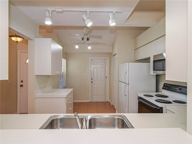 kitchen featuring light tile patterned flooring, white cabinetry, kitchen peninsula, sink, and white appliances