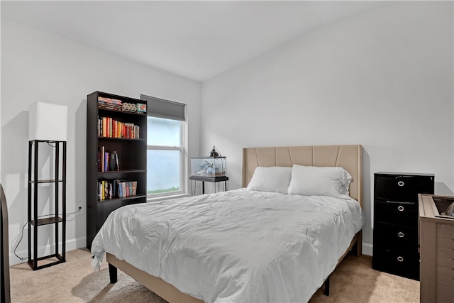 bedroom featuring light colored carpet and lofted ceiling