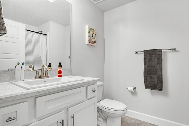 bathroom featuring tile patterned flooring, vanity, toilet, and a textured ceiling