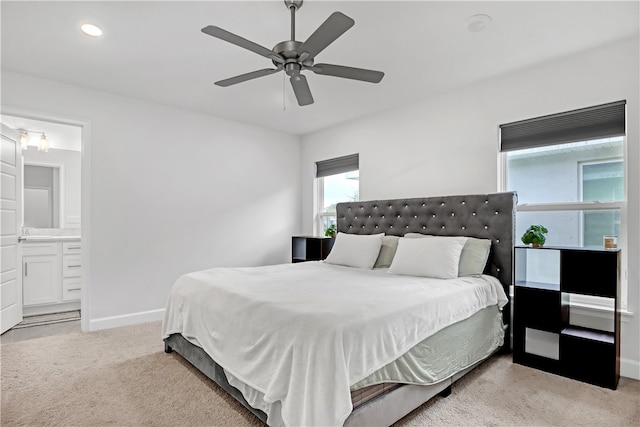 carpeted bedroom featuring ceiling fan and ensuite bath