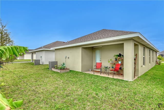 back of property featuring a lawn, central AC unit, and a patio area