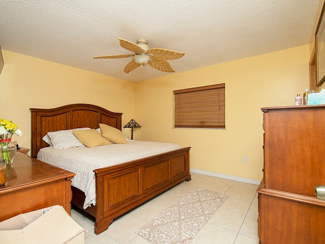 tiled bedroom with ceiling fan and a textured ceiling