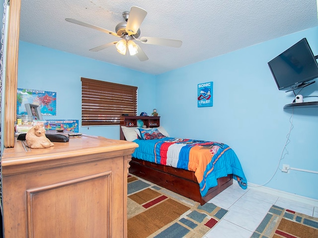 tiled bedroom featuring a textured ceiling and ceiling fan