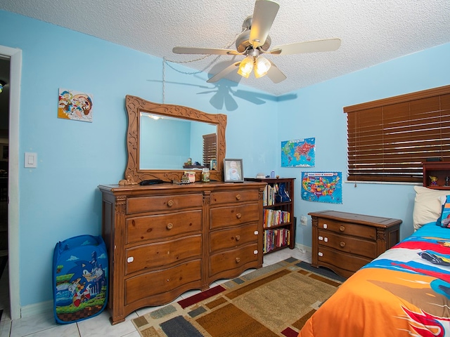 tiled bedroom with a textured ceiling and ceiling fan