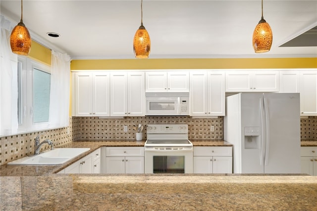 kitchen featuring pendant lighting, white appliances, backsplash, white cabinets, and sink