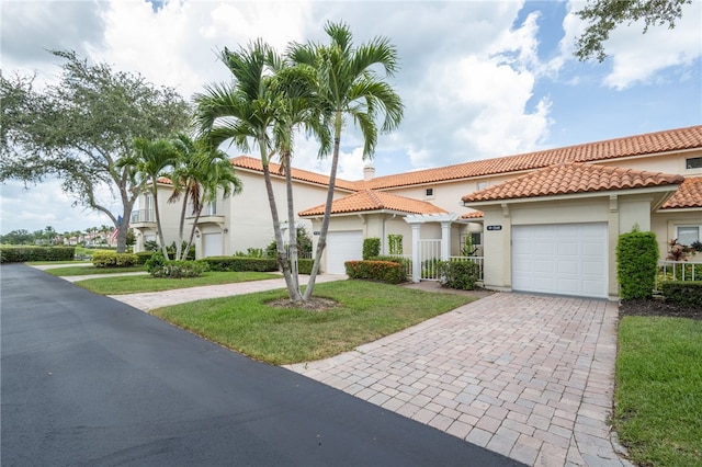 mediterranean / spanish-style home featuring a garage and a front lawn