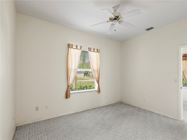 carpeted spare room featuring ceiling fan