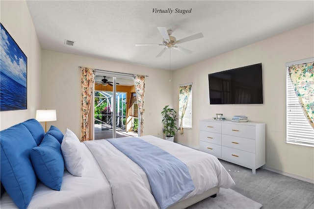 bedroom with ceiling fan, access to exterior, a textured ceiling, and light carpet