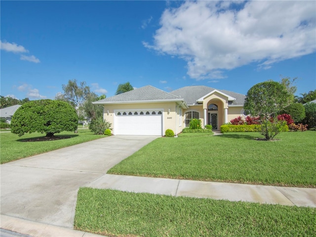 ranch-style home featuring a garage and a front lawn