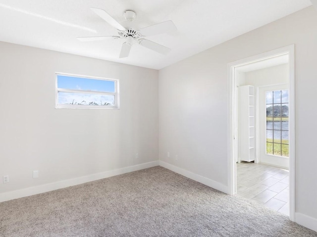 carpeted spare room with ceiling fan